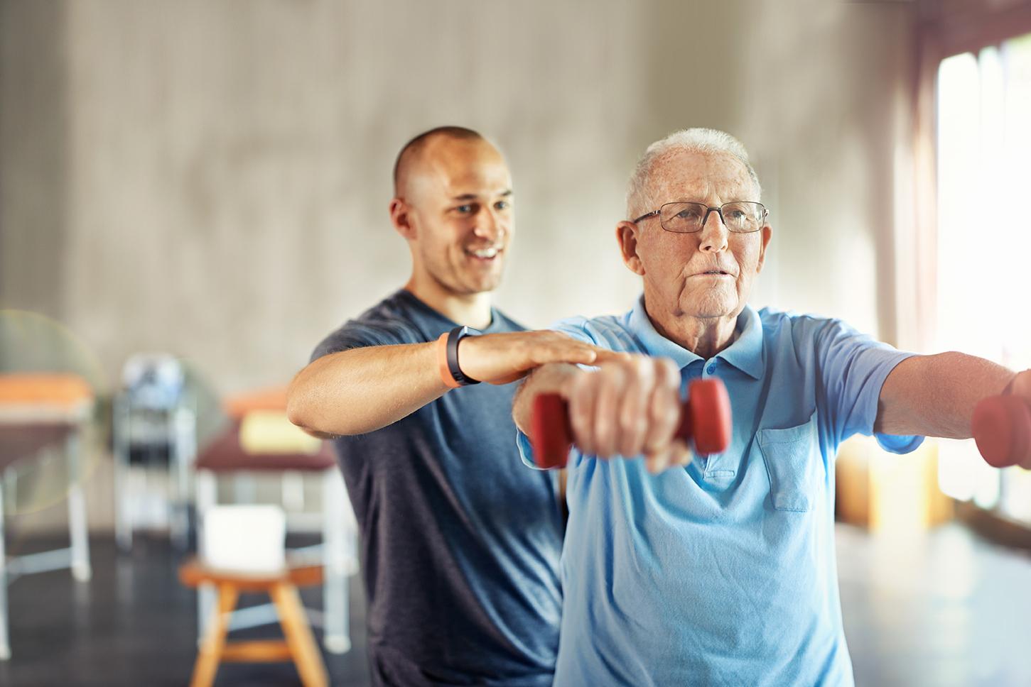 A professional assists older adults with exercise bands in Lewisville, TX