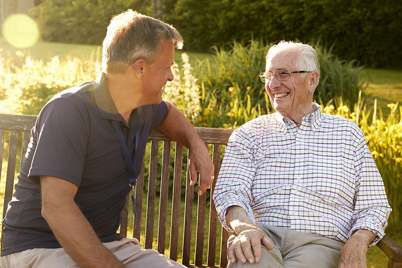 Two older people sitting and laughing together in Lewisville, TX