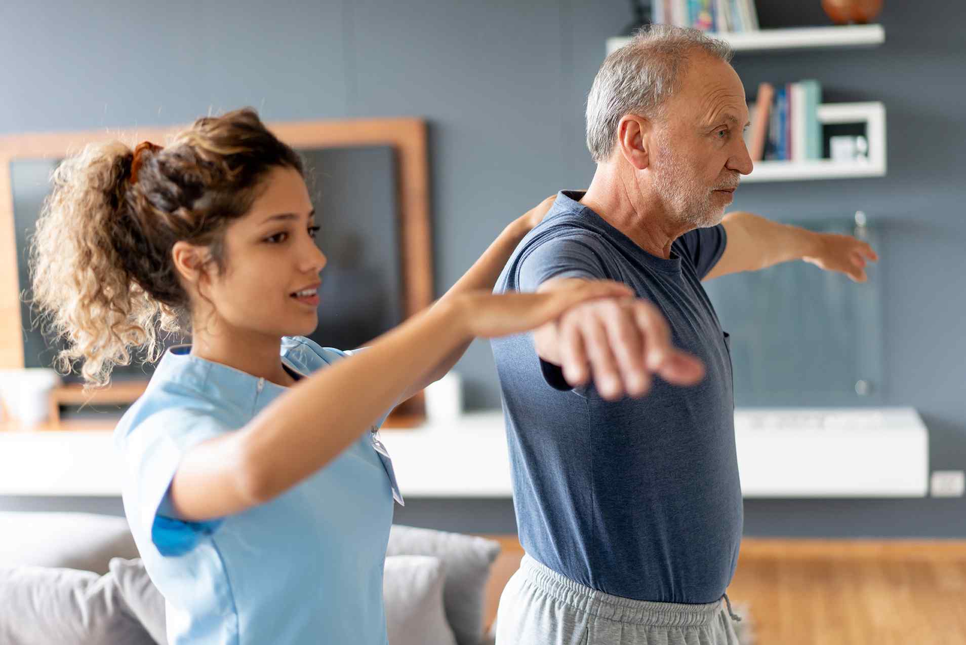 Female professional helps older man exercise, short-term rehabilitation in Lewisville, TX